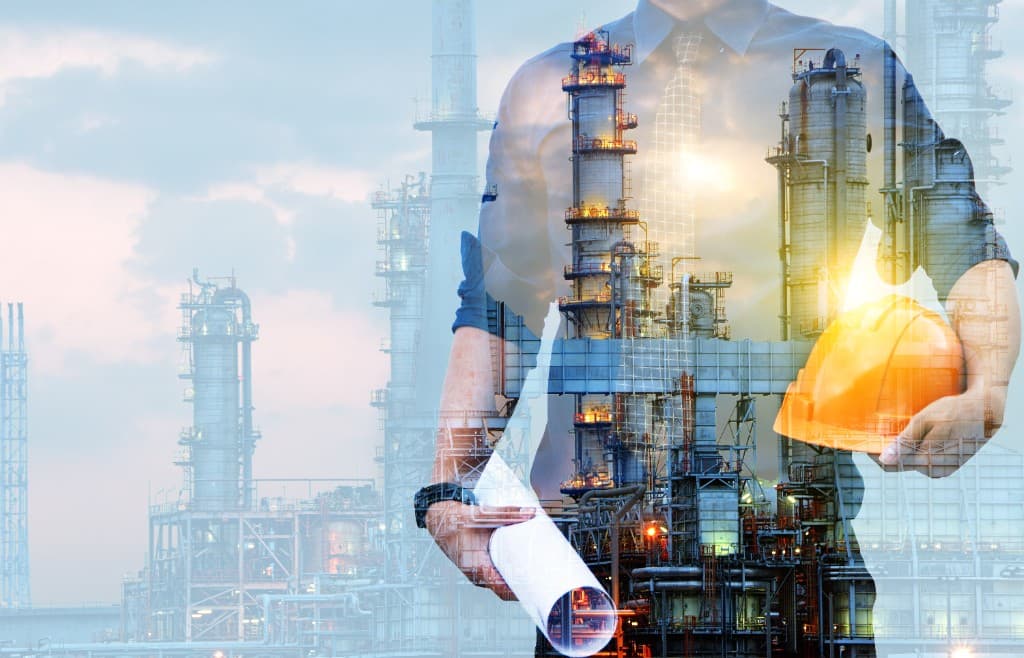 Project professional with plans and hard hat overlaid on an industrial capital facility
